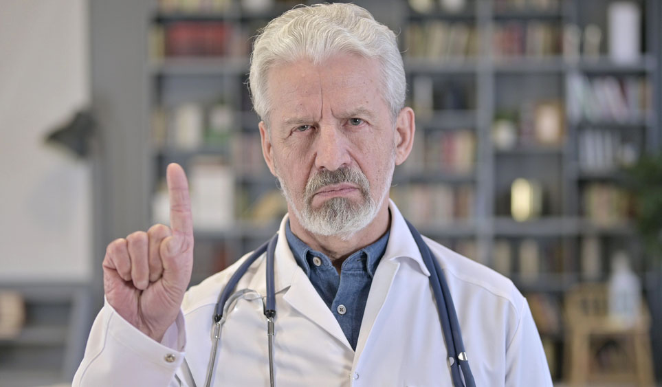 Photo of older white doctor with beard shaking his finger "no"